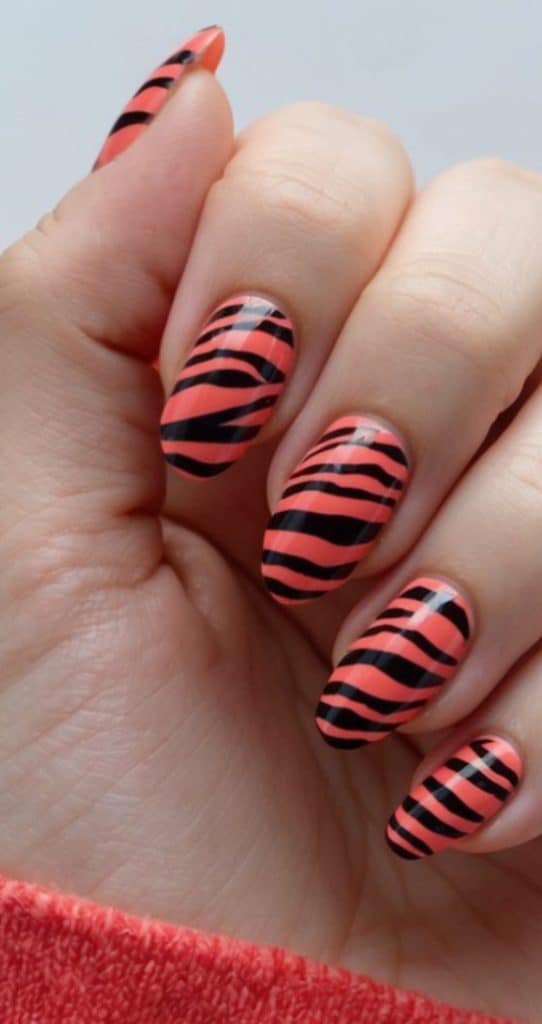 Vibrant coral zebra stripes on nails