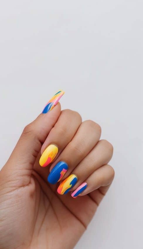 Vibrant abstract nail art designs with bold splashes of color on a clean, white background