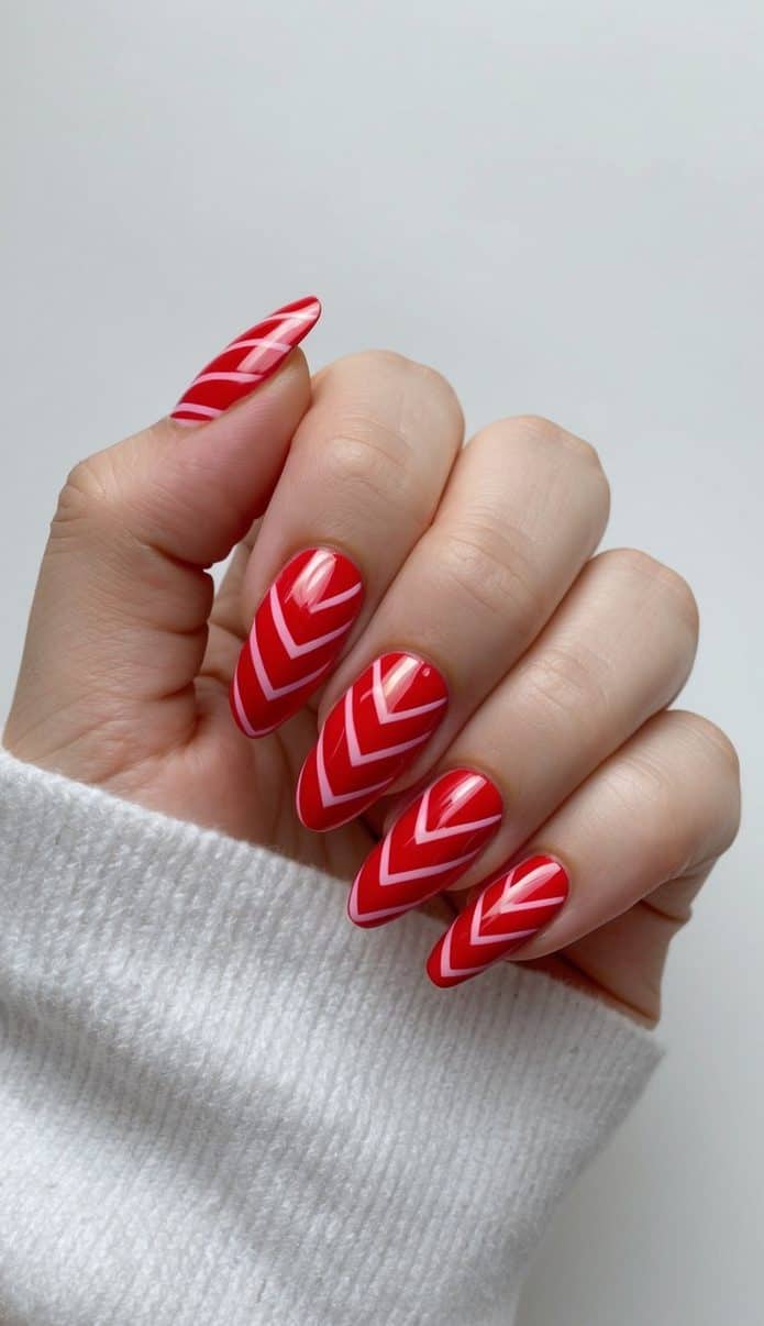 Vibrant red chevron lines on acrylic nails, bold and chic