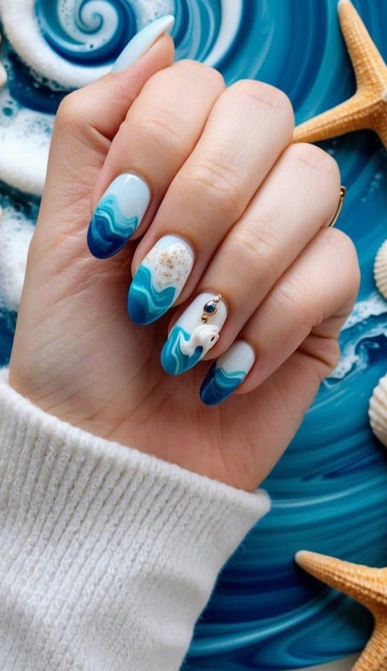 Ocean-inspired nails feature cool, calming hues, a sprinkle of gold glitter, and 3D embellishments