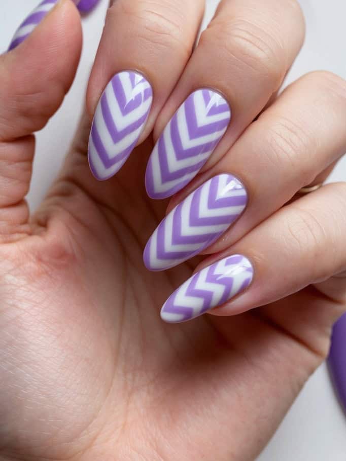 A close-up of lavender chevron patterns on nails, with various dreamy lavender nail art designs in the background
