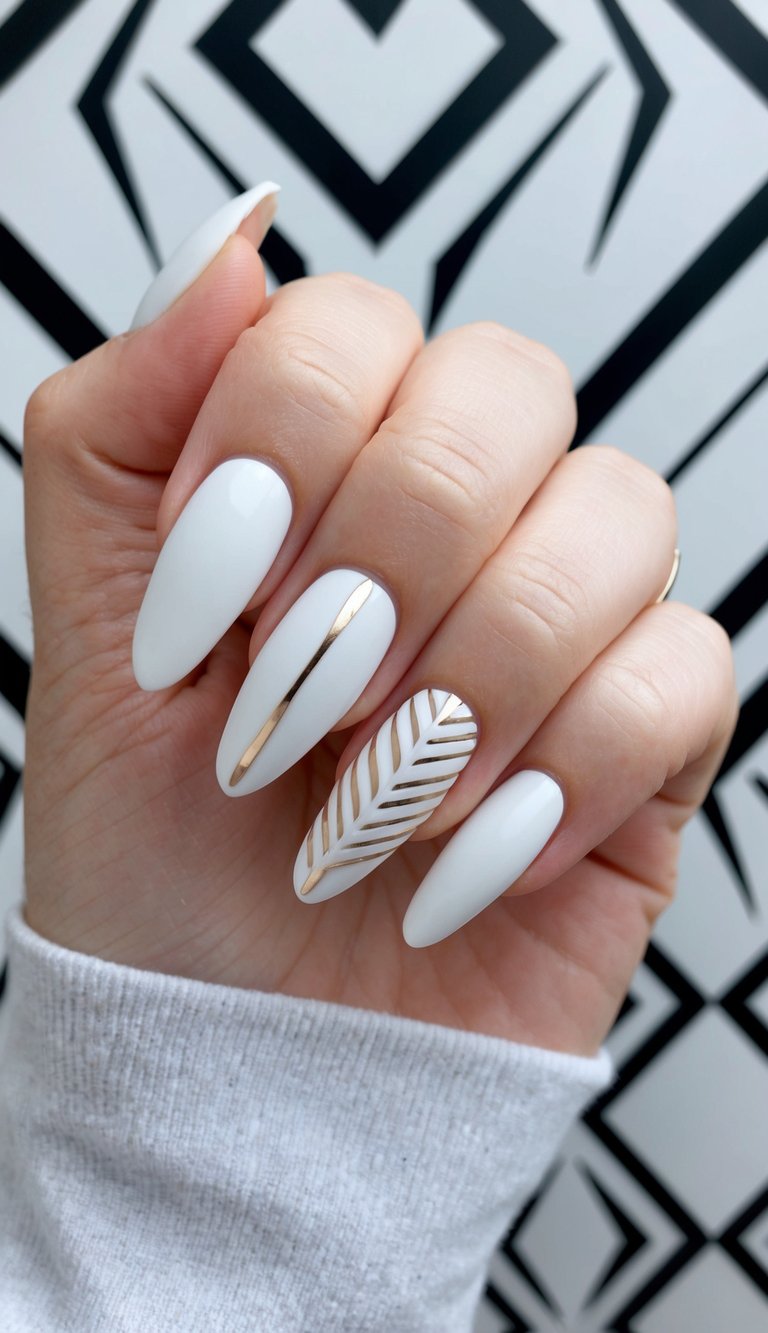 Stylish matte white nails featuring a sleek gold stripe and gold geometric leaf pattern over almond-shaped tips.