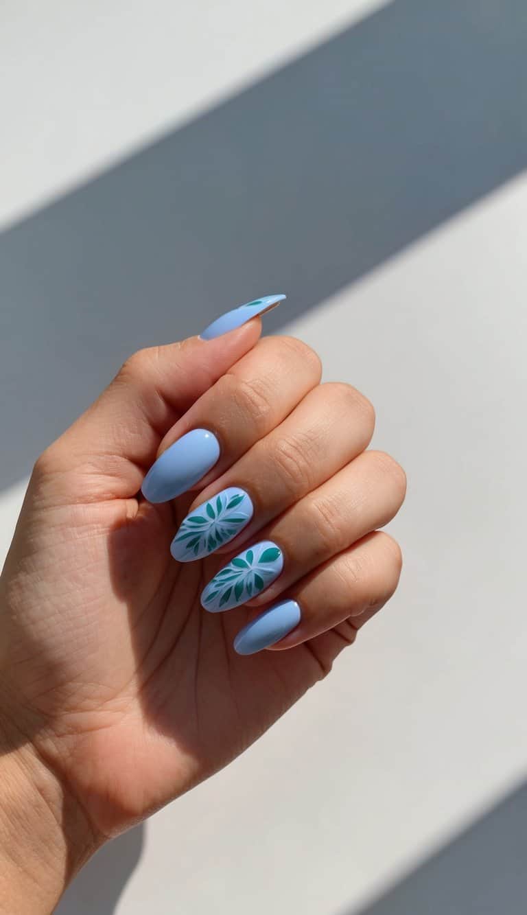 A close-up of periwinkle nails adorned with delicate leaf designs on accent nails for a nature-inspired touch