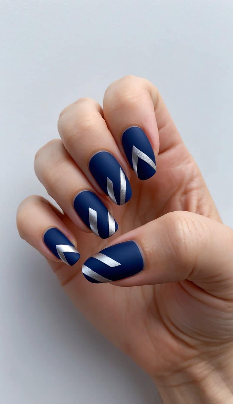 A navy geometric art with silver accents on navy blue nails