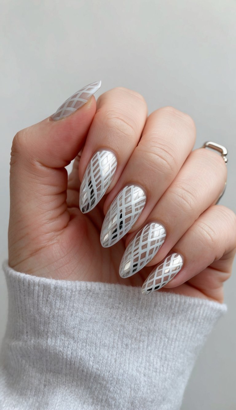 A close-up of sleek silver lattice nail art designs on a neutral background