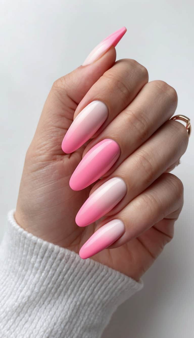 A close-up of pink ombre nails on a white background