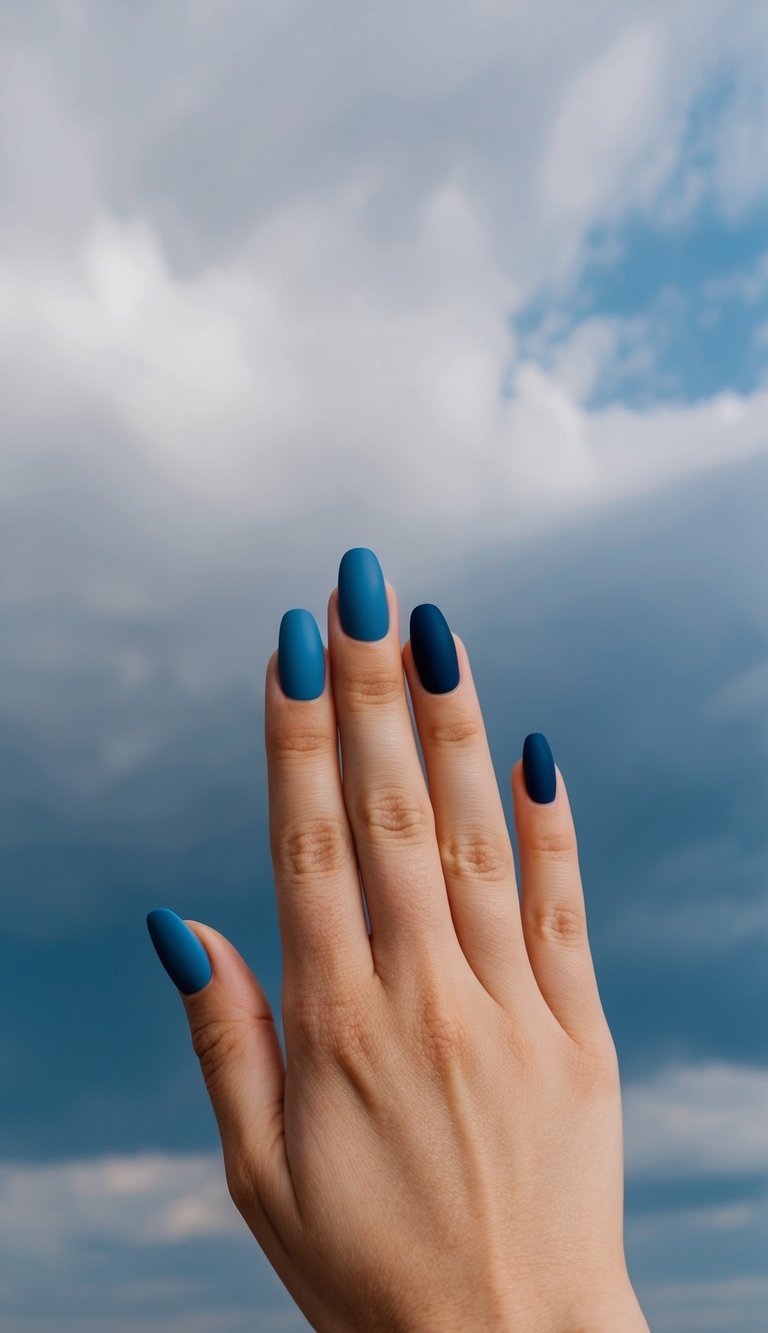 A serene, cloudy sky in dusty blue hues, with 50 unique blue matte nail art designs displayed