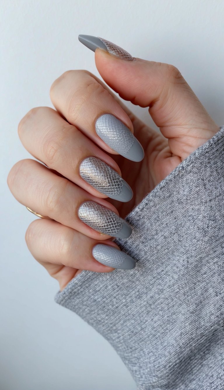 A close-up of gray ombre nails with a metallic mesh pattern