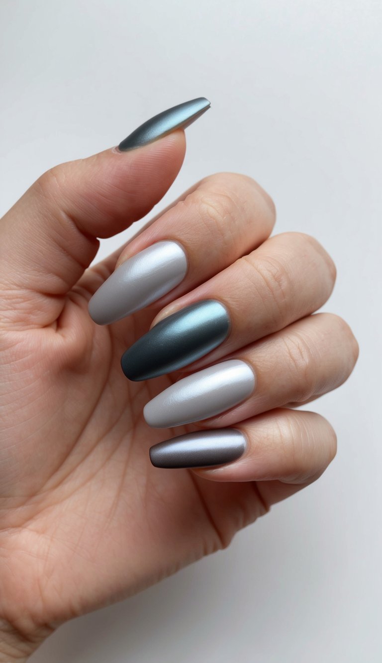 A set of silvery satin finish nails in various shades of gray, smoothly transitioning from light to dark, creating an elegant ombre effect