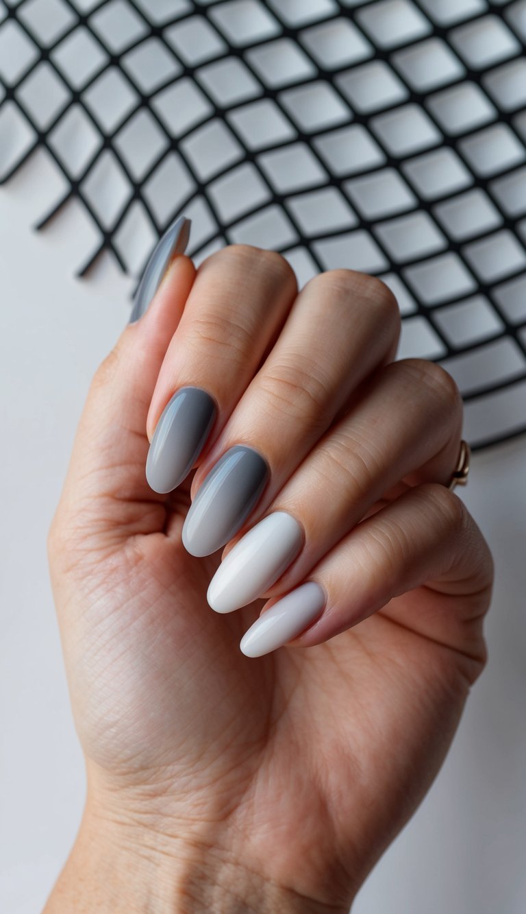 A hand holding a gray ombre nail with a modern mesh design in the background