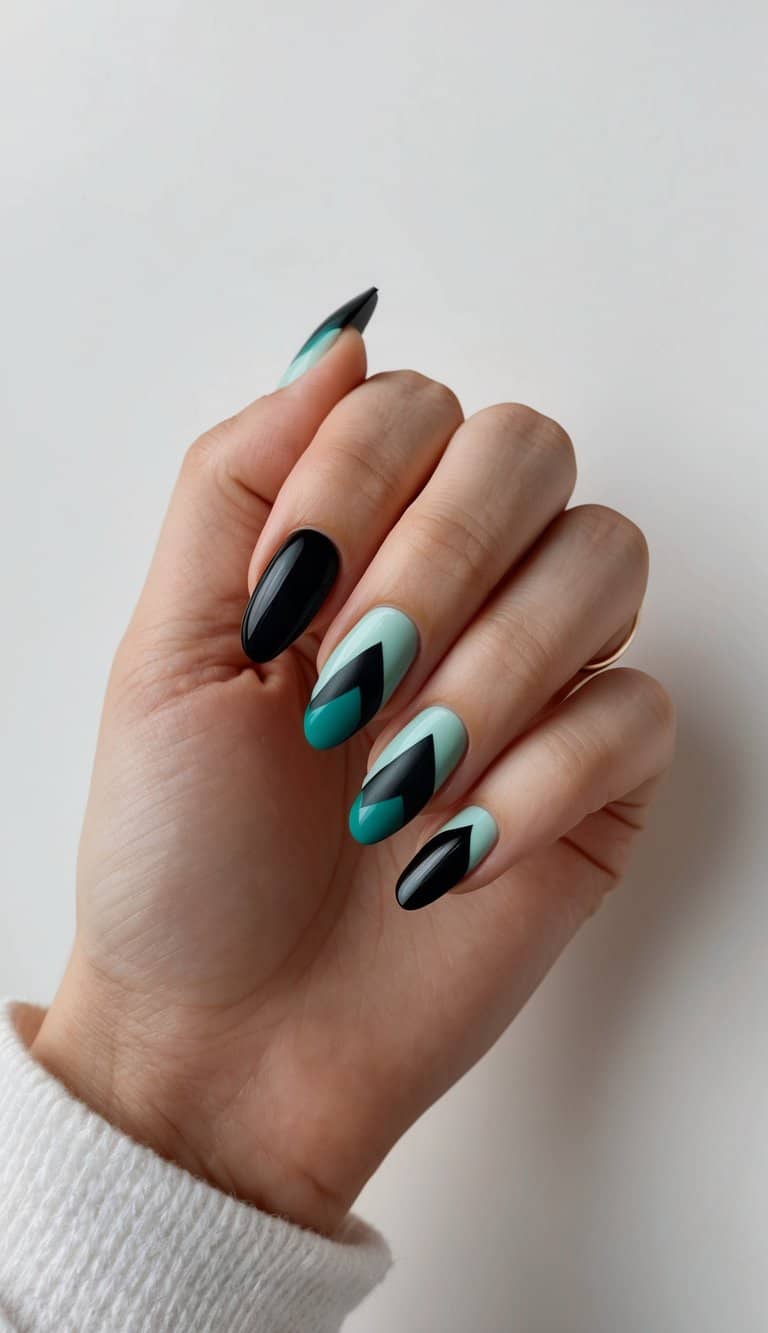A close-up of black and teal geometric nail art designs on a clean, neutral background