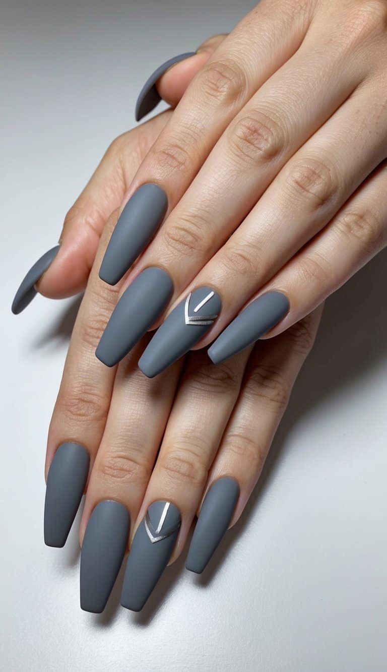 A close-up of matte gray nail art designs on a sleek, edgy background