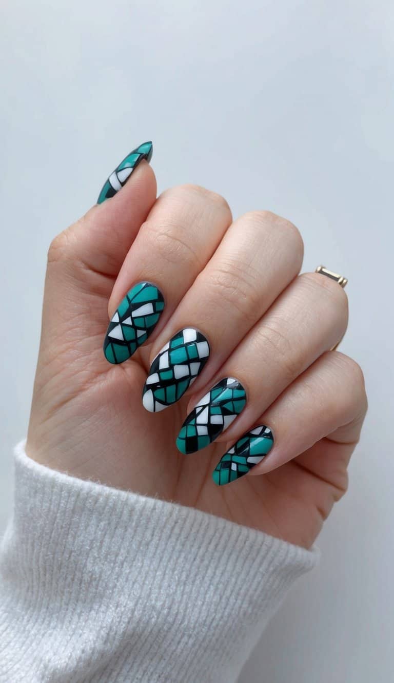 A close-up of teal and black mosaic nail art designs