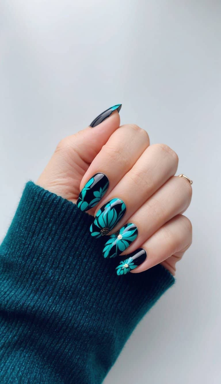 A close-up of black and teal floral nail art designs on a smooth surface
