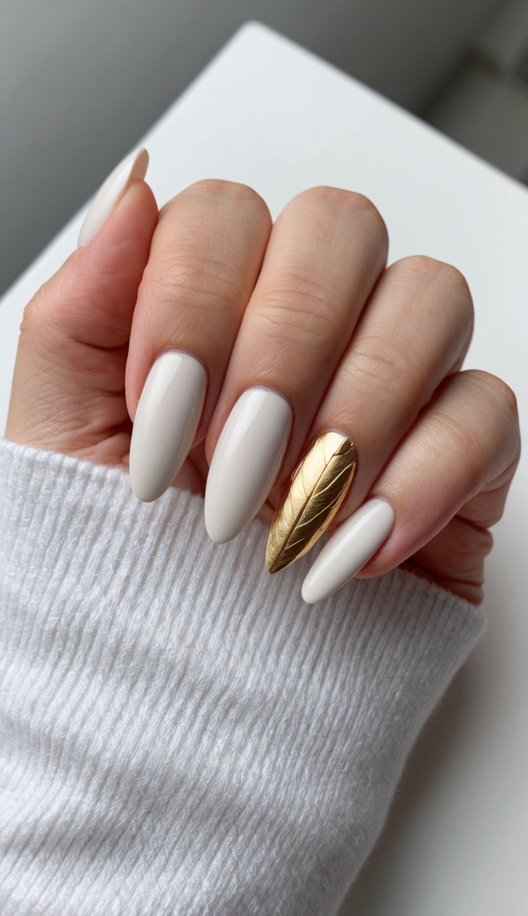 A close-up of a single golden leaf on a sleek, minimalist nail