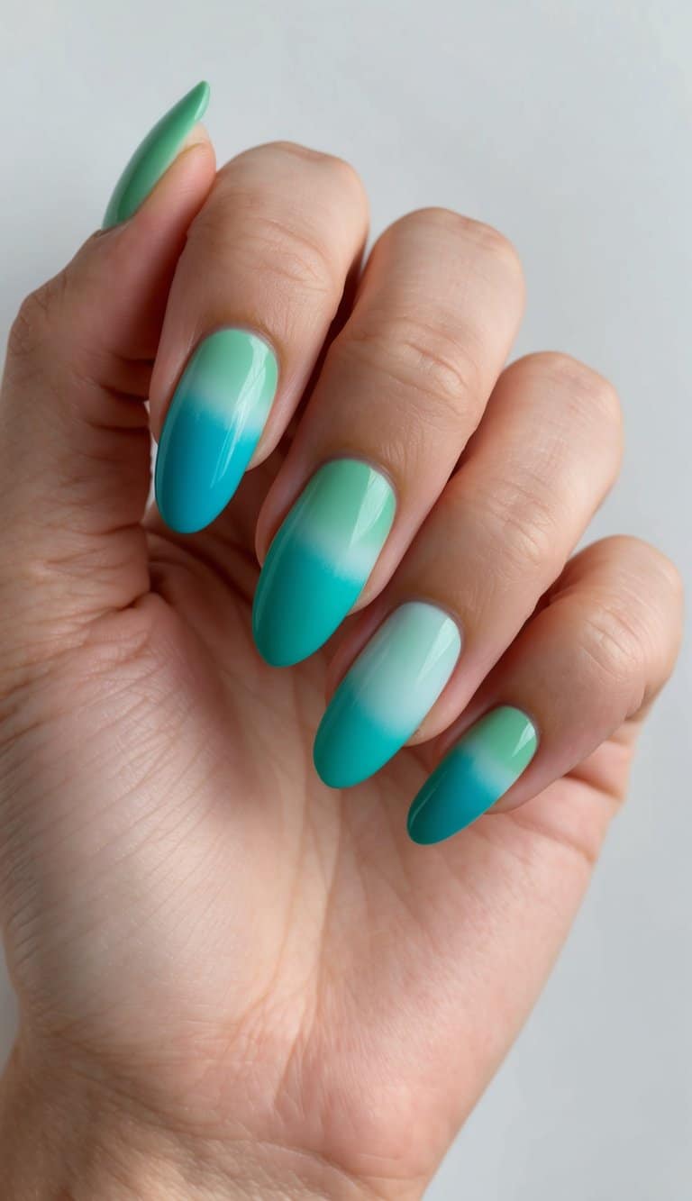 Vibrant ombre nails in jade and seafoam shades, blending seamlessly in a gradient pattern