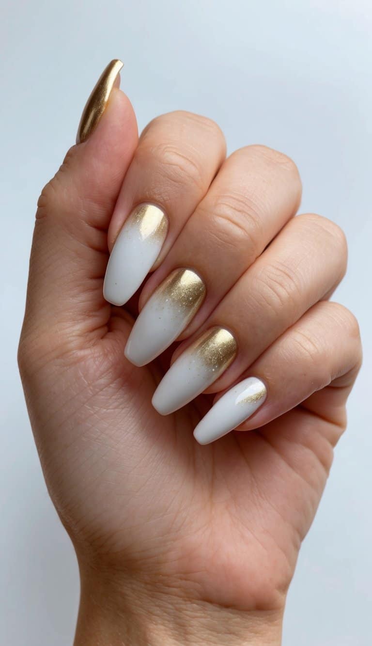 A hand holding a gold and white gradient nail art design