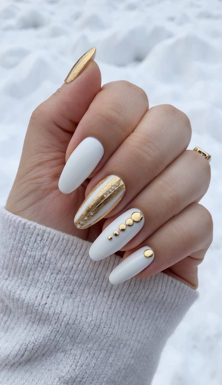 A close-up of white and gold nail art designs on a snowy background