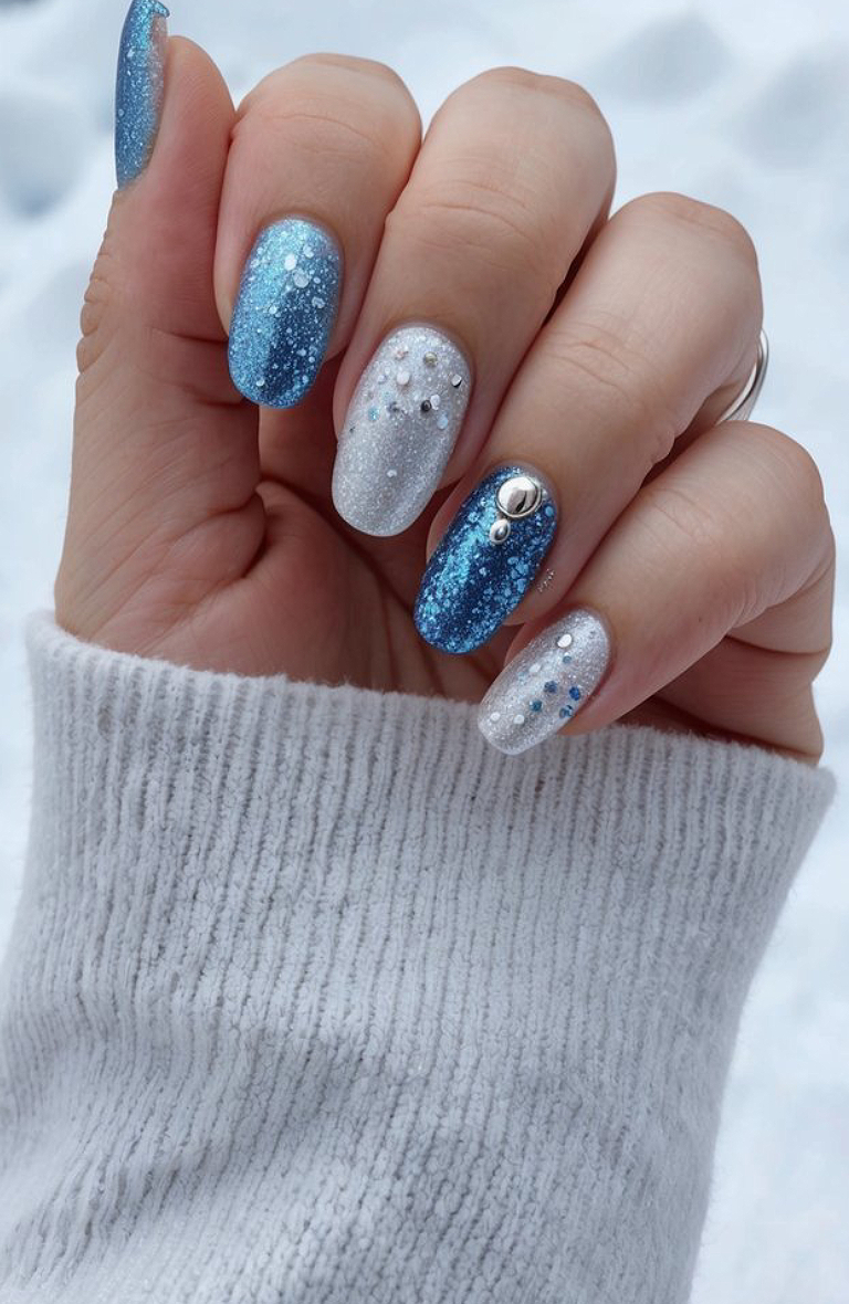 Icy blue and silver glitter nails, finished with crystal gems for a frosted touch