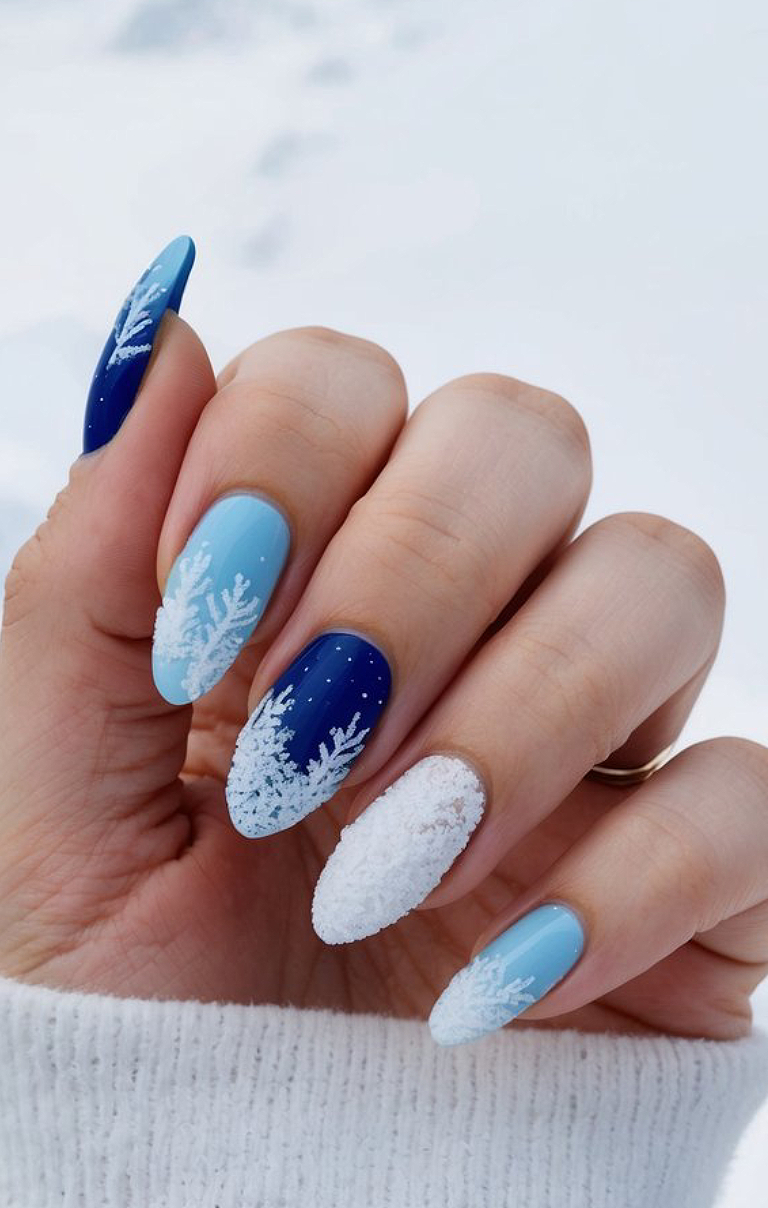 Icy blue and silver glitter nails get extra charm from scattered snowflake dots and shiny metallic studs—just like a shimmering winter wonderland on your fingertips!