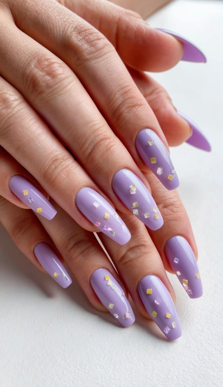 A close-up of lavender nails adorned with delicate confetti-like designs