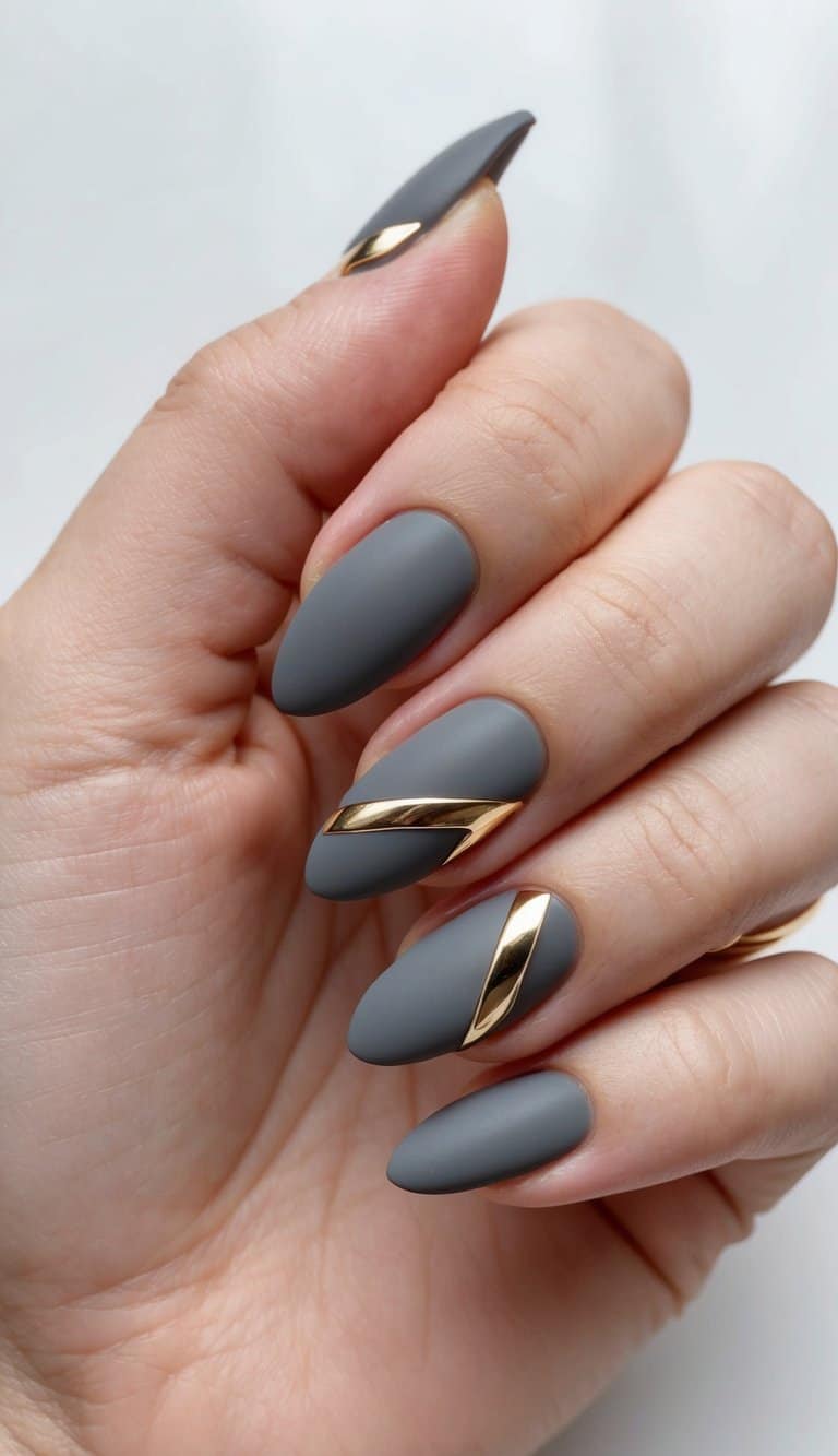 A close-up of elegant gray nails with geometric gold accents on a matte finish