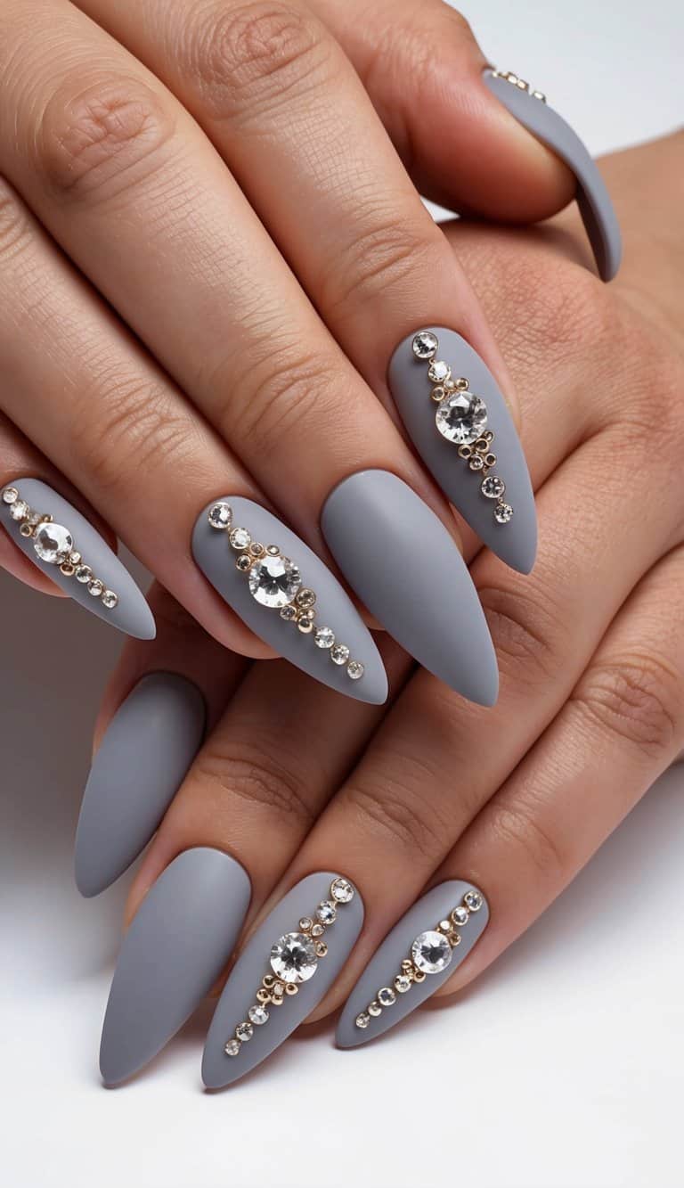 Soft gray nails adorned with rhinestones in elegant, matte designs