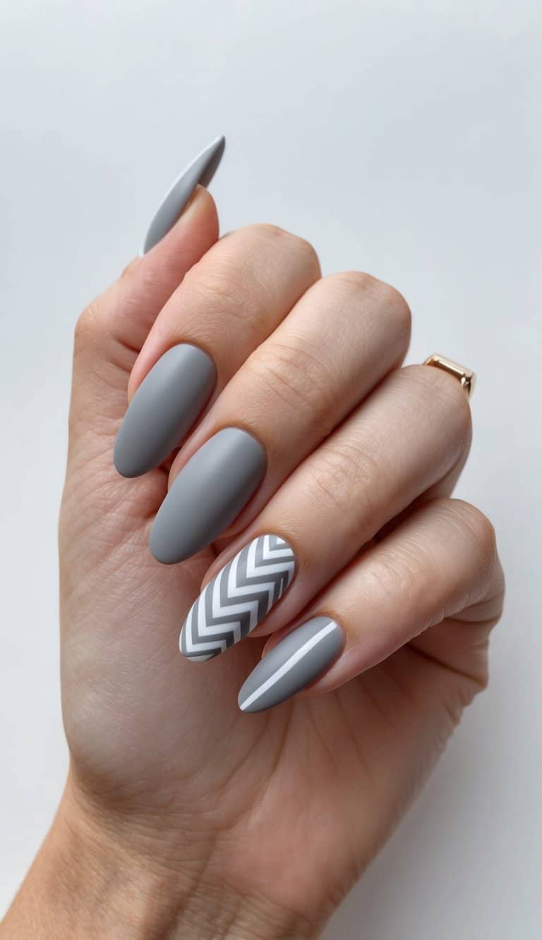 A close-up of elegant gray nail art designs with subtle chevron patterns, featuring a matte finish