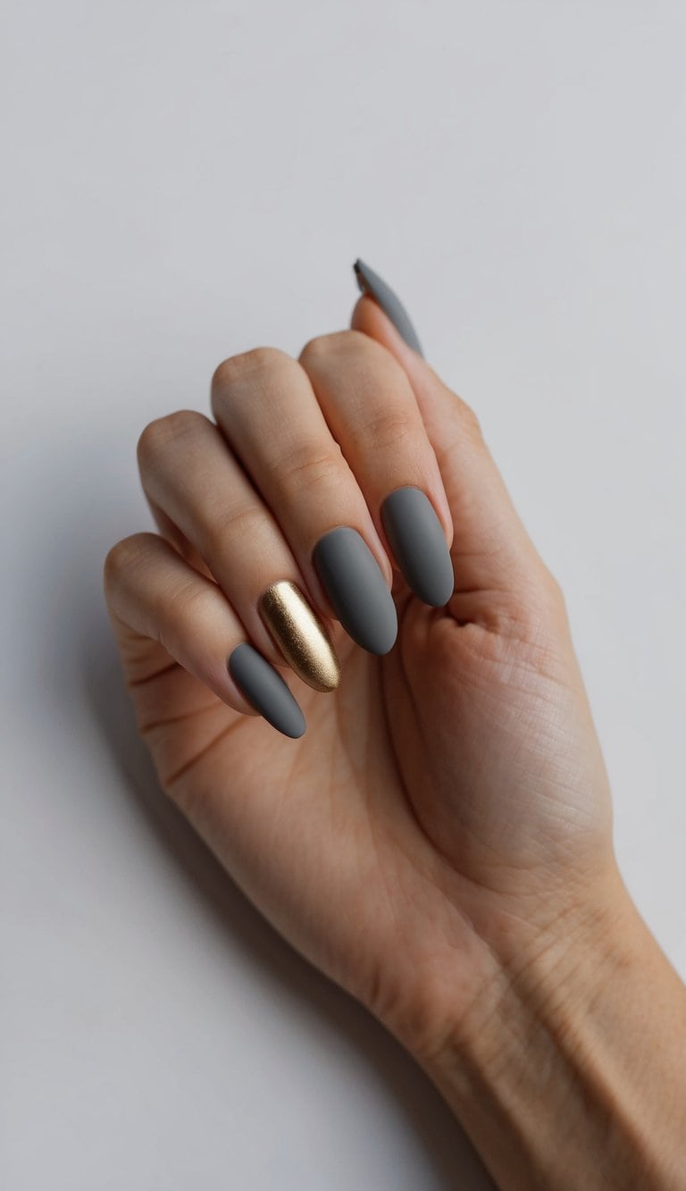 A matte grey nail with a bold gold accent