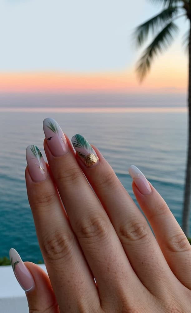 Lush green palm fronds on soft pink to white ombre nails, with a hint of gold foil