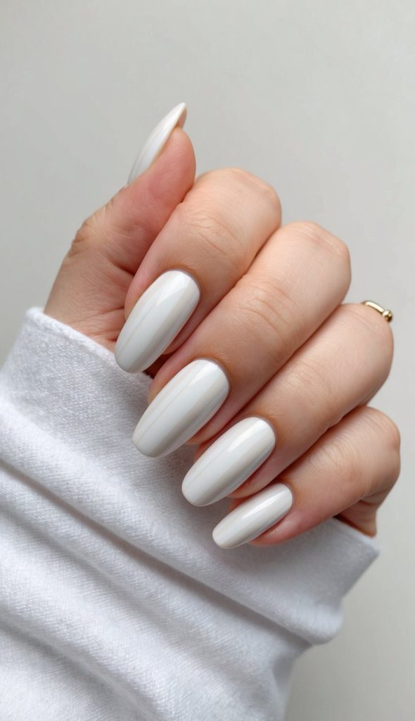 A stylish set of ivory-white nails with a smooth, glossy surface and refined shape, embodying the essence of minimal yet chic formal nail art.