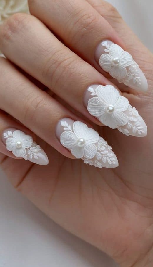 A delicate, intricate floral appliqué design adorns the nails, adding a touch of elegance to the bridal look