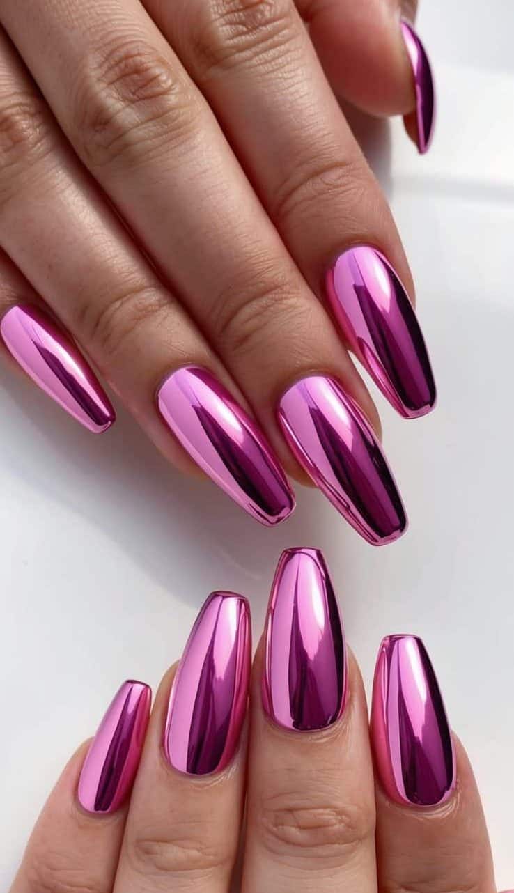 A close-up of pink chrome nails with bubblegum hues, reflecting light in a sleek and glossy finish