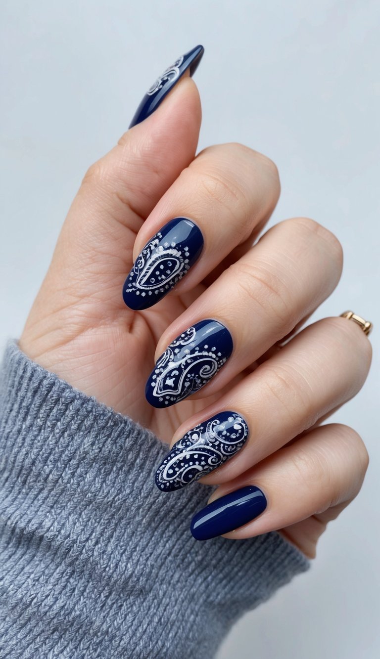 A close-up of navy blue nails with intricate paisley designs