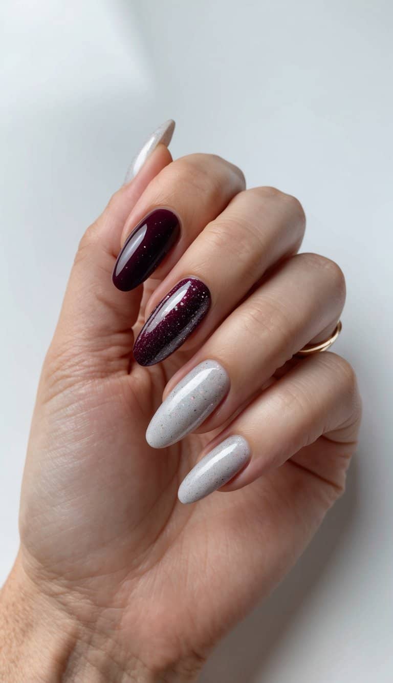 A maroon and silver glitter fade nail art design on a clean, well-manicured nail