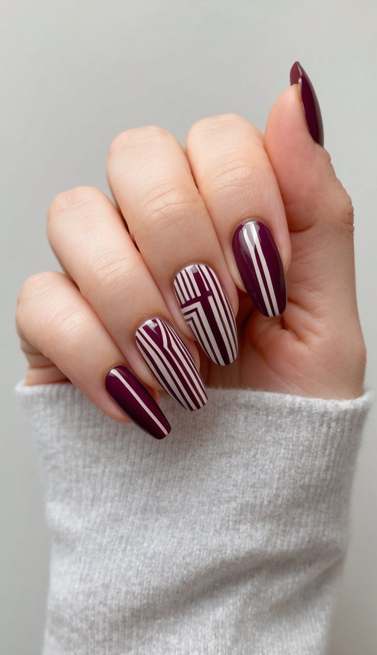 A close-up of maroon geometric nail art on a neutral background