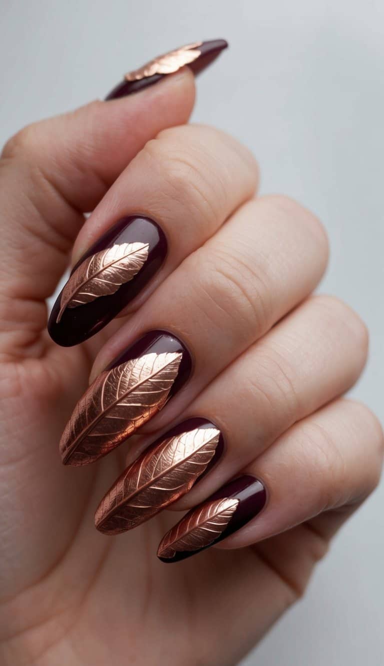 A close-up of maroon nails with intricate copper leaf detailing