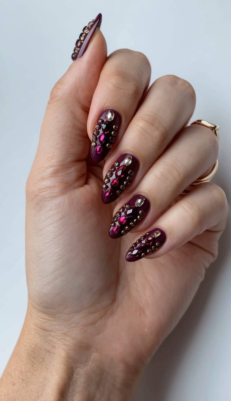A rich maroon jewel-encrusted nail art display