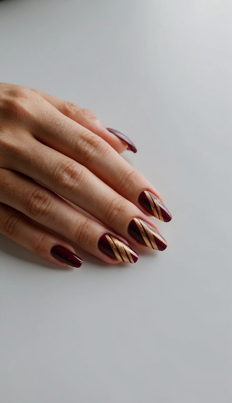 Maroon and gold diagonal lines nail art on a clean, manicured surface