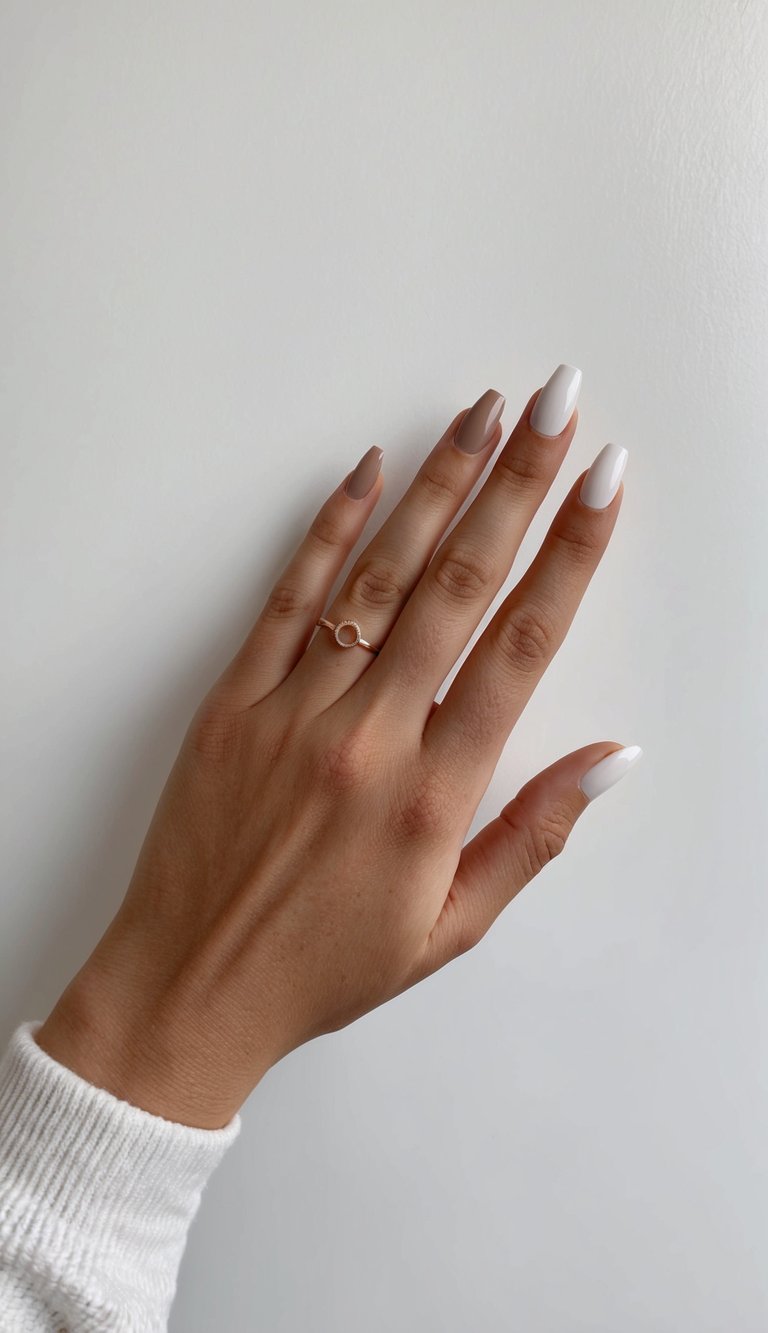 A hand with two-toned nails against a clean, minimalist backdrop