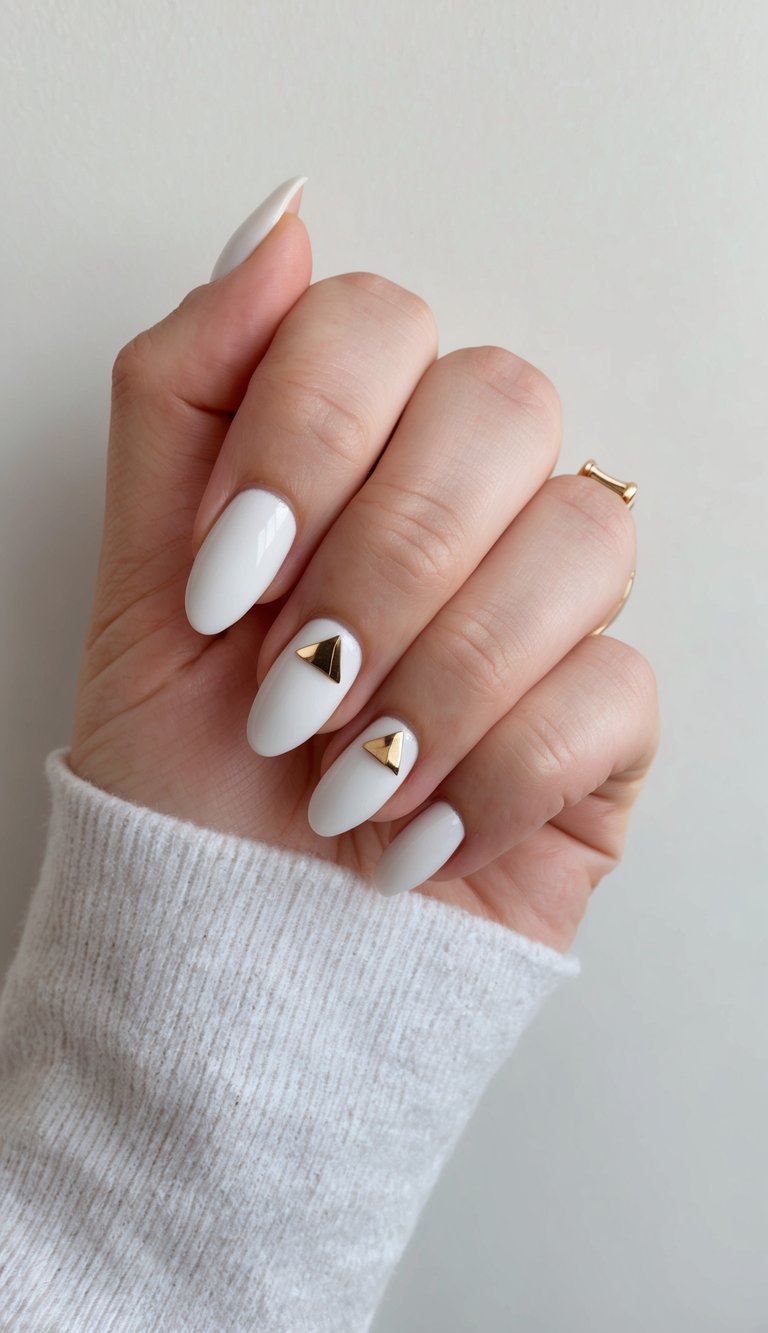 A hand with minimalist triangle nail art against a neutral background