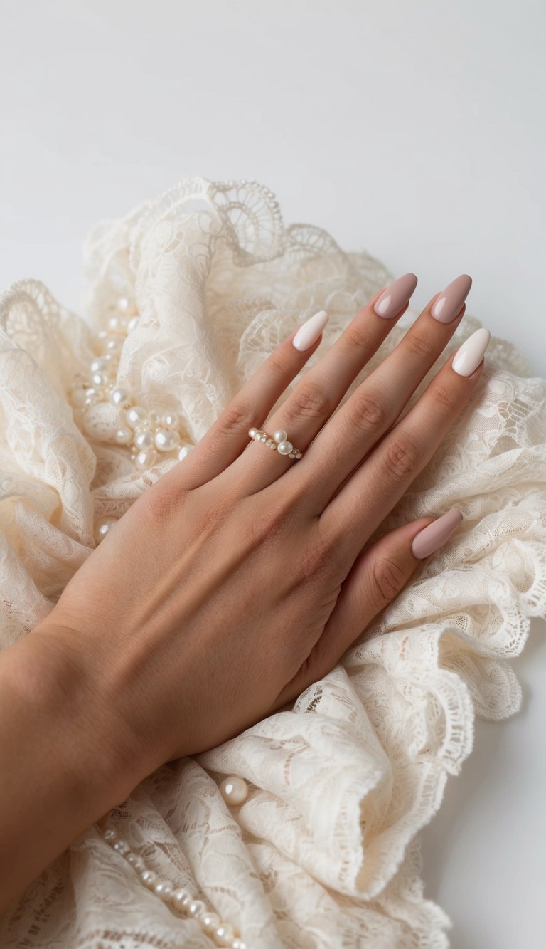 A hand with neutral-colored nails resting on a bed of ivory lace and pearls