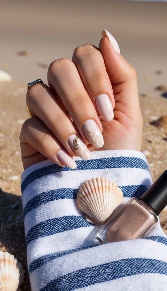 A sandy beach with a striped beach towel, seashells, and a bottle of nail polish. Waves crashing in the background
