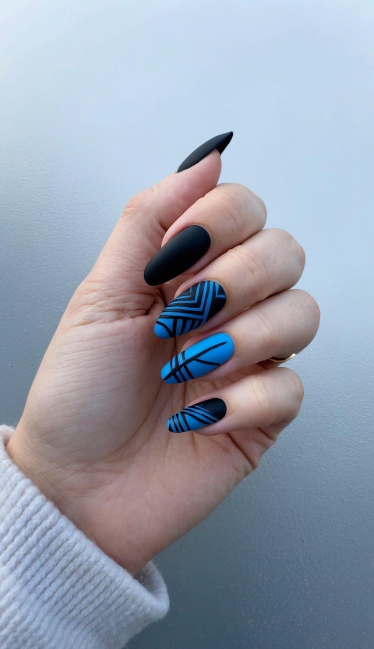 A close-up of black and blue nail art designs on a frosty, reflective surface