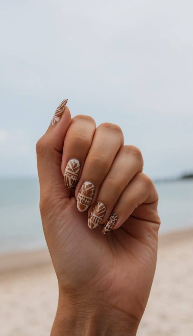 A tranquil beach scene with tribal patterns in earthy nail art hues