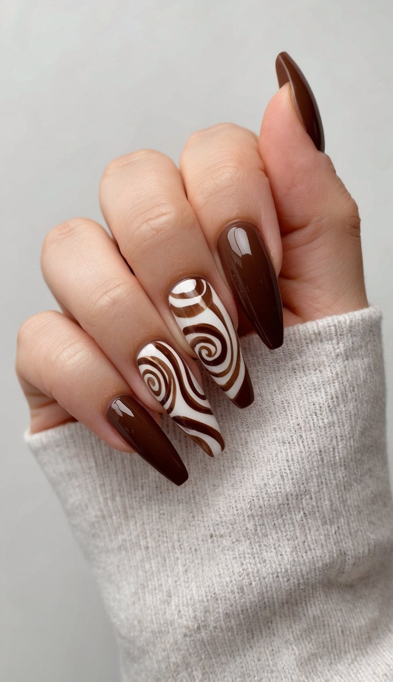 A close-up of brown nail art designs with swirling carob patterns on a neutral background