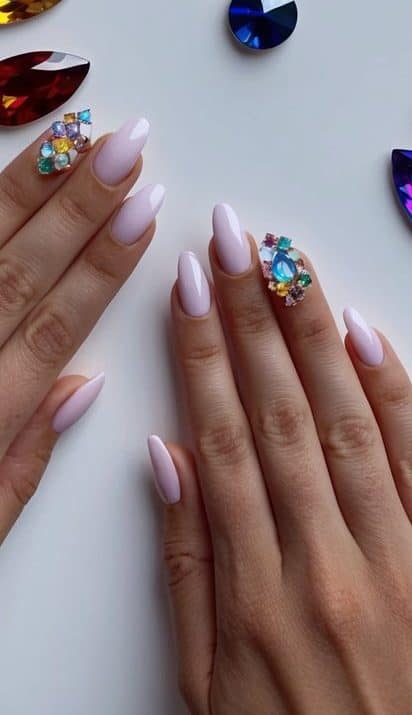 A collection of 3D gem accents in various colors arranged on a flat surface for nail art inspiration
