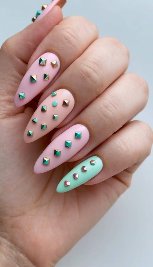 A close-up of edgy studded nail art with playful designs and pastel shades