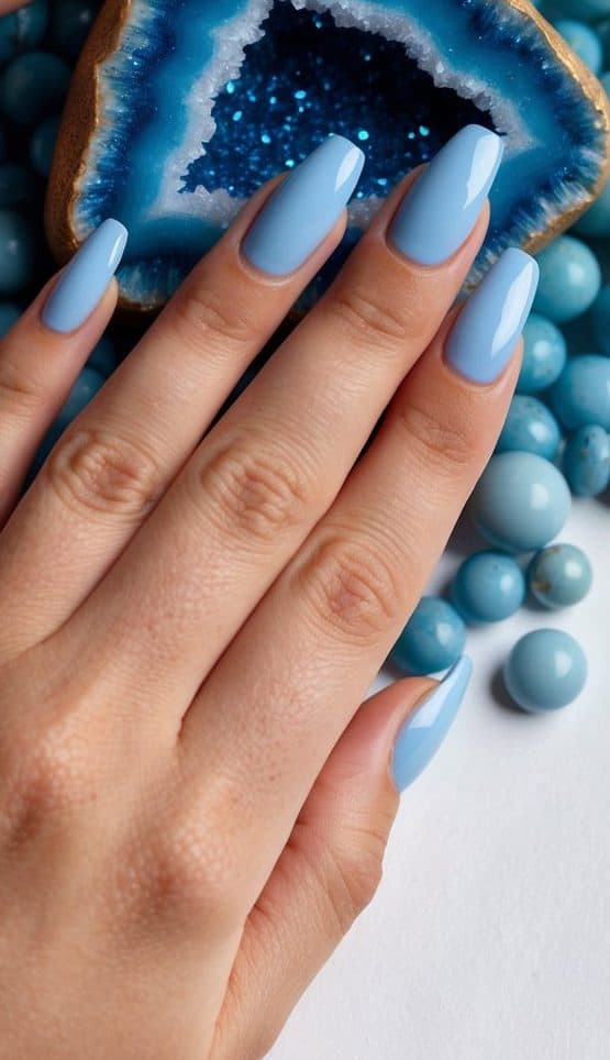 A sophisticated sky-blue nail design with a glossy finish, inspired by gemstones, creating a chic and polished manicure.