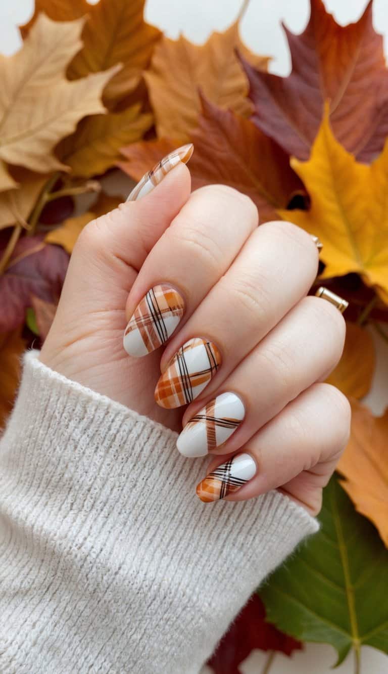 A cozy fall scene with plaid patterned nails against a backdrop of autumn leaves and warm tones